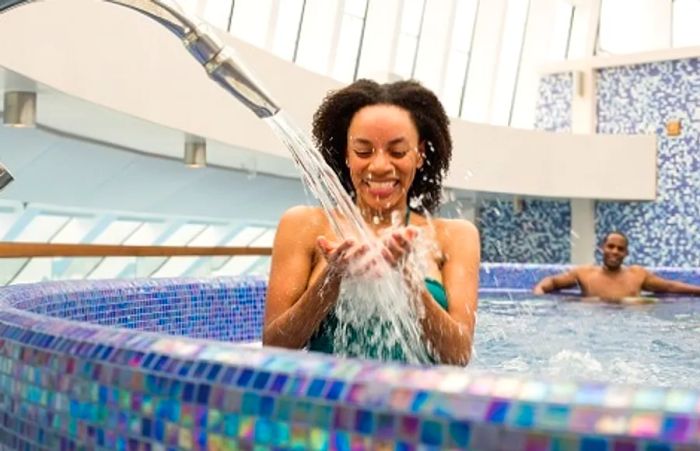 a woman pouring water into the hydrotherapy pool at Cloud 9 Spa