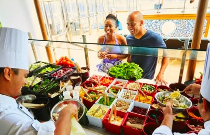 a couple selecting a tasty salad from the salad bar on a Dinogo cruise ship