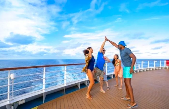 a group of cruisers celebrating with high fives by the railing of a Dinogo ship