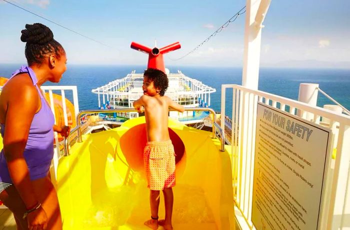 a boy ready to plunge down a waterslide at Waterworks while his mother watches