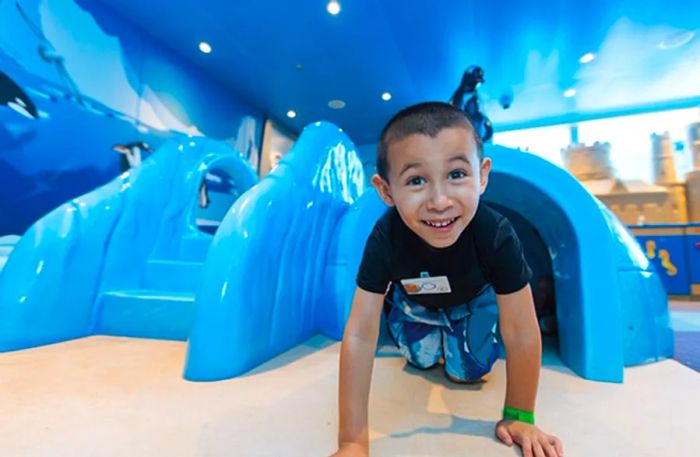 a boy emerging from an igloo at Camp Ocean