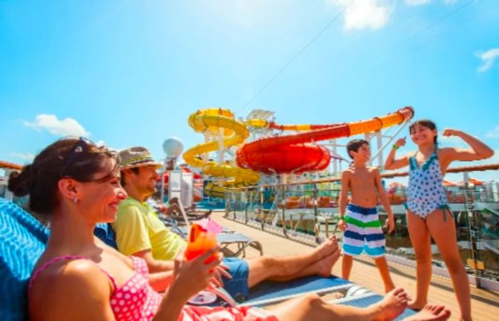 parents relaxing on beach chairs while their two children prepare to enjoy water activities