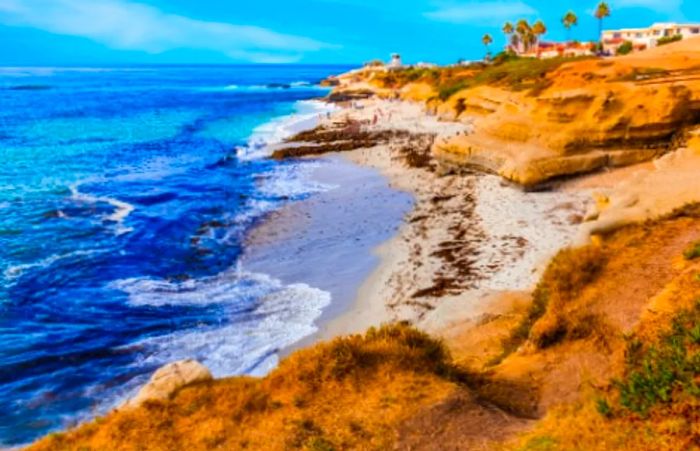 An aerial view of the beach and cliffs surrounding La Jolla Cove in San Diego