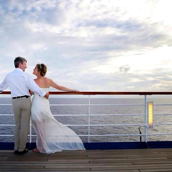 couple enjoying a sunset view from their cruise ship