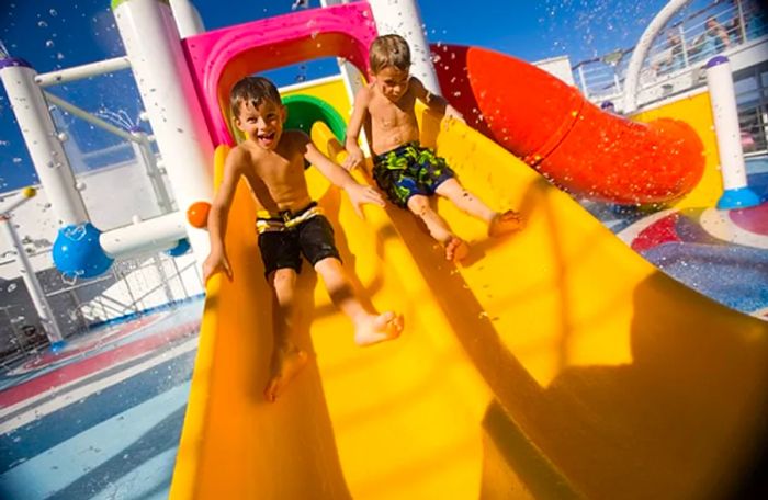 two boys sliding down a yellow waterslide at WaterWorks