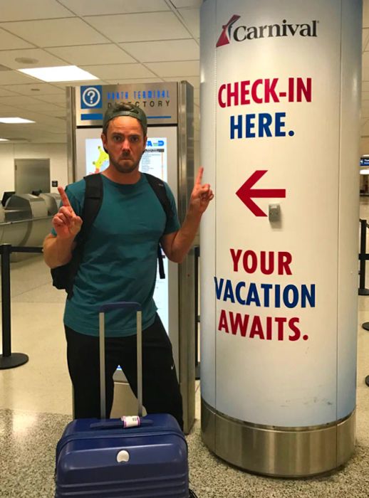 A husband standing at the cruise check-in area