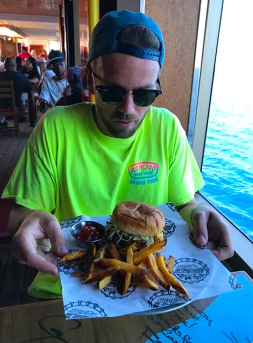 man in a vibrant green shirt enjoying a burger