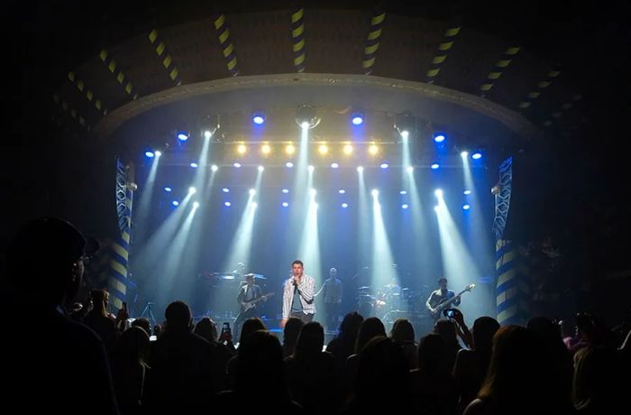 Nick Jonas singing with a blue and white backdrop