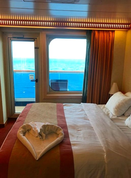 A bed adorned with a heart-shaped towel in the cabin