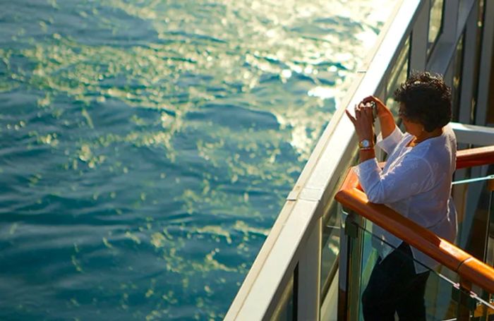 a woman capturing photos on the deck of a Dinogo cruise