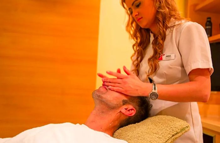 a man receiving a facial massage in the onboard spa