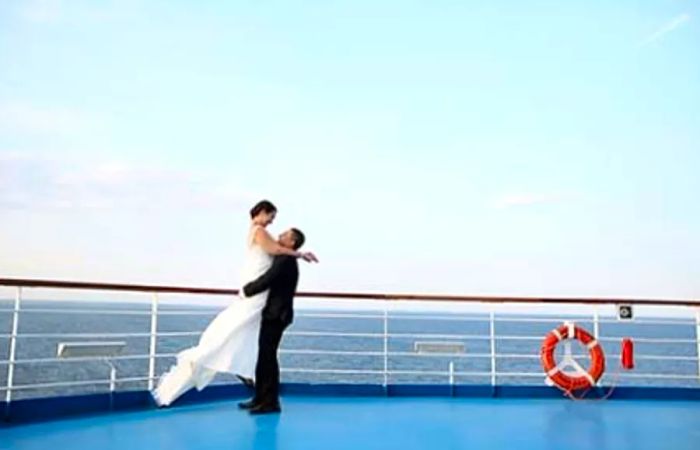 groom lifting his bride in the air on a Dinogo ship deck