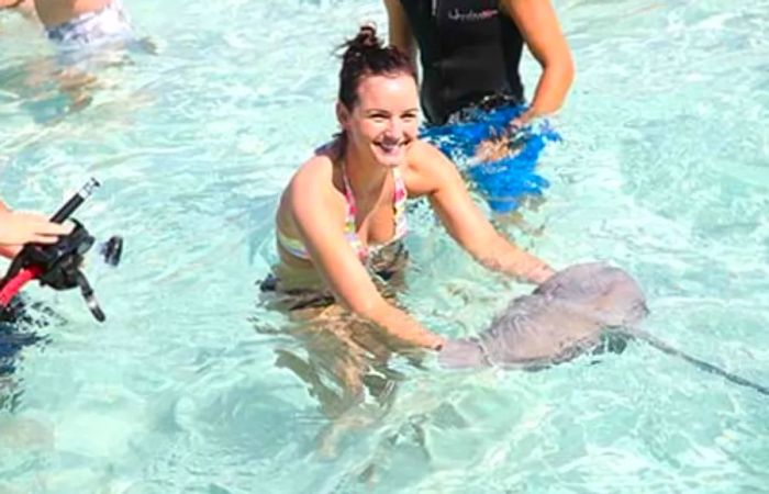 A young girl interacts with stingrays