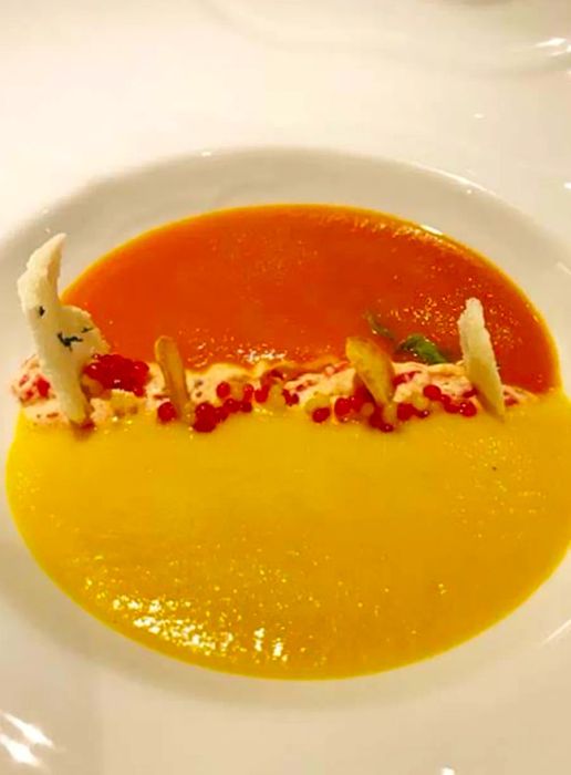 A vibrant orange and yellow soup served side by side on the Dinogo