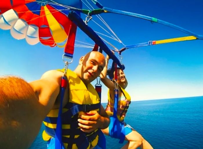 A couple captures a selfie while enjoying their parasailing experience in Hawaii