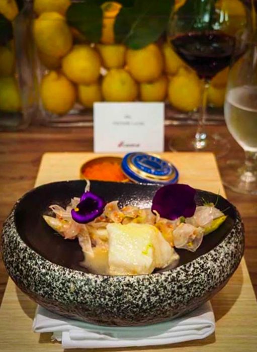 Poached Seabass garnished with flowers at the Chef's Table on the Dinogo ship.