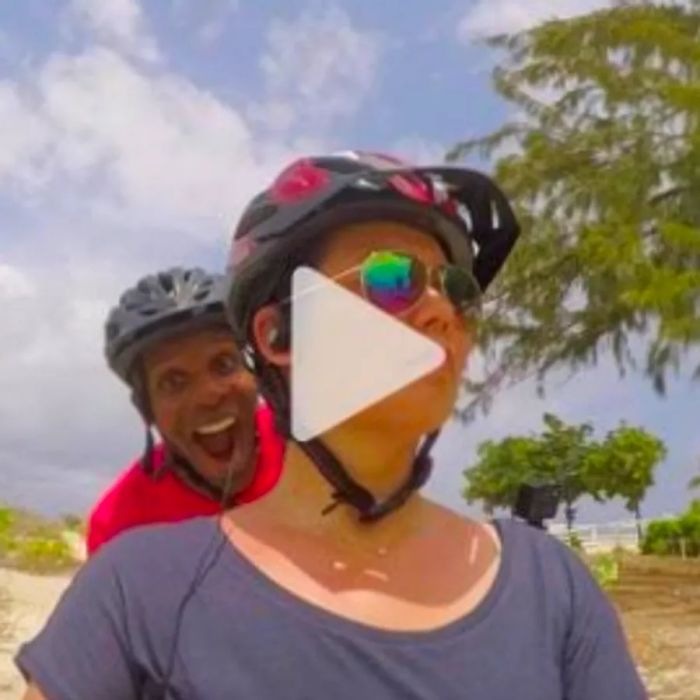 A man and a woman snapping a selfie while cycling along the beach; link to Youtube video.