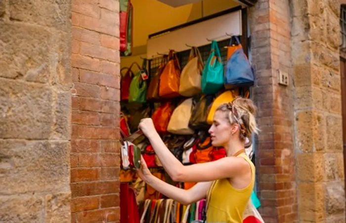 a woman admiring a leather bag in a shop in Italy