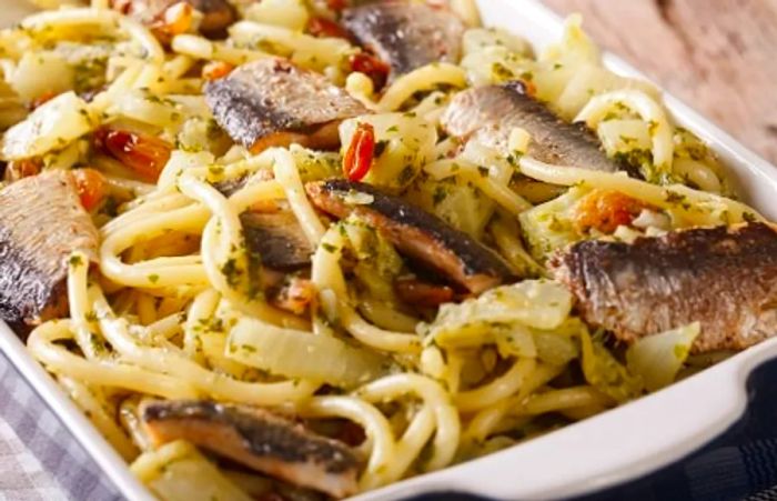 sardine pasta garnished with pine nuts and oregano