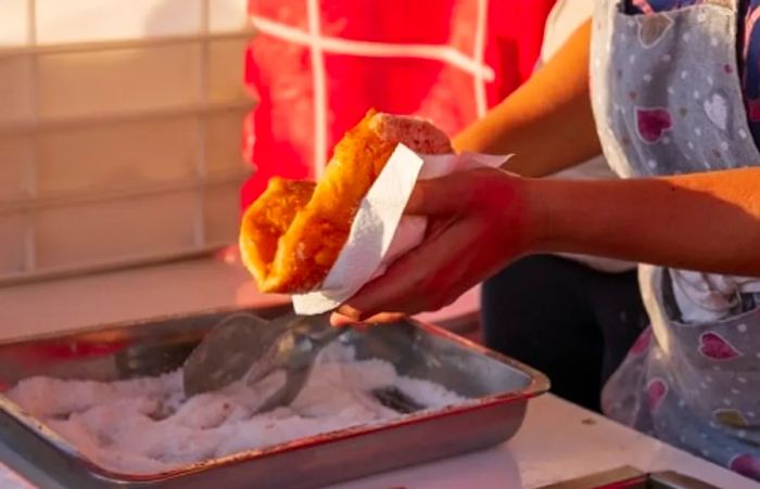 A woman preparing fried pizza at a market in Italy