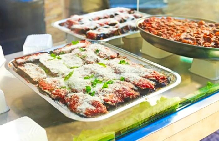 eggplant lasagna, a classic Sicilian dish, displayed at a Sicilian bakery