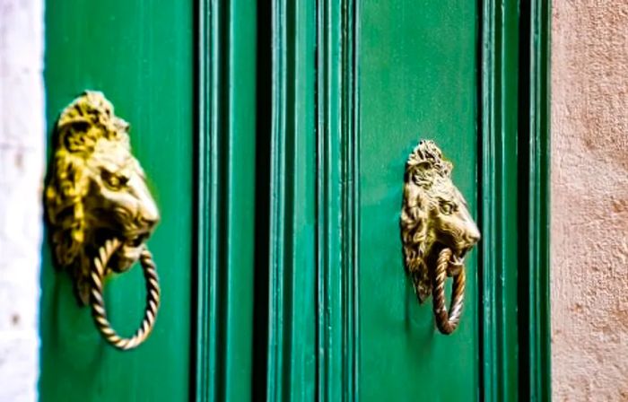 decorative door knockers on the entrance of a building in Italy