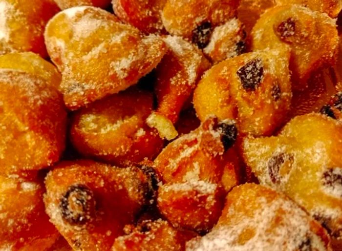 a plate of sweet raisin pastries known as frittelle