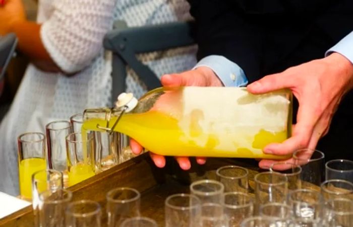 a waiter serving a glass of limoncello