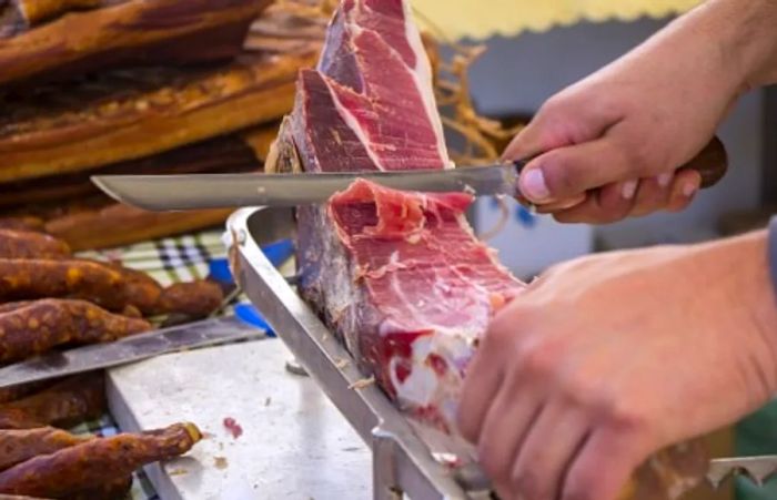 a butcher slicing prosciutto at a local market