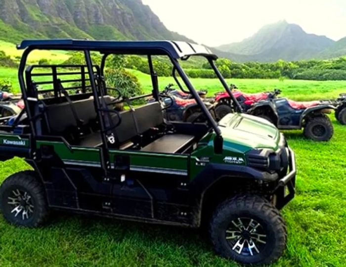 a Hawaiian valley featuring a golf cart and ATVs in the background