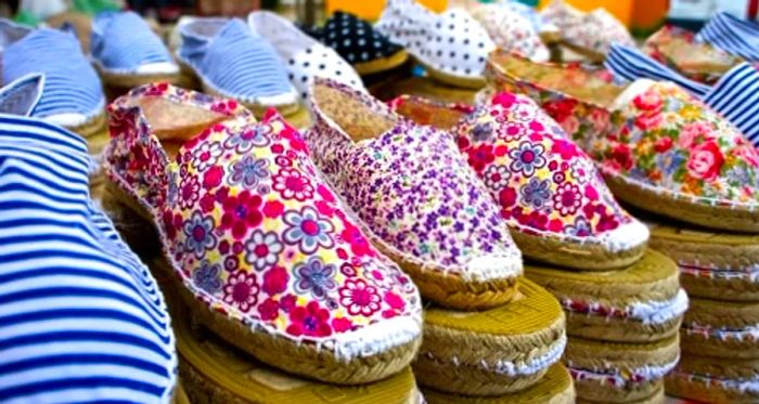 a collection of floral espadrilles showcased in a Barcelona market