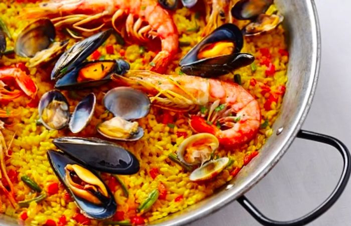 a skillet brimming with a special Spanish seafood rice dish known as paella