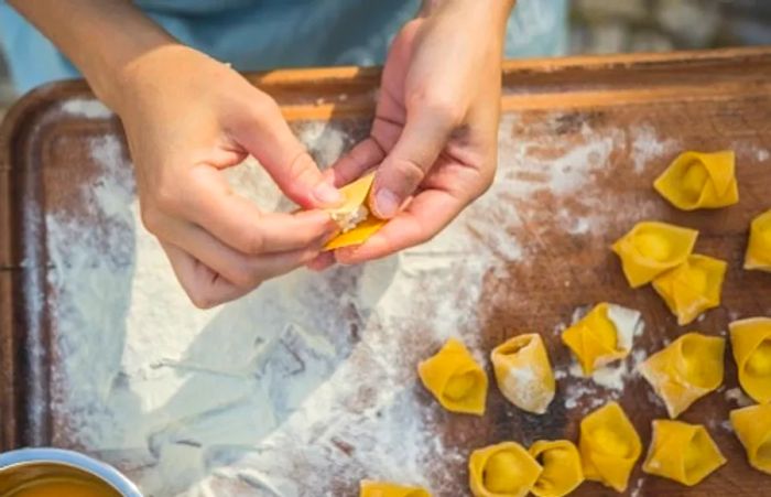 an individual skillfully crafting tortellini pasta by hand