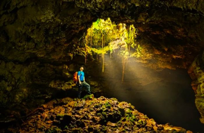 a backpacker exploring a volcanic cave in the Azores