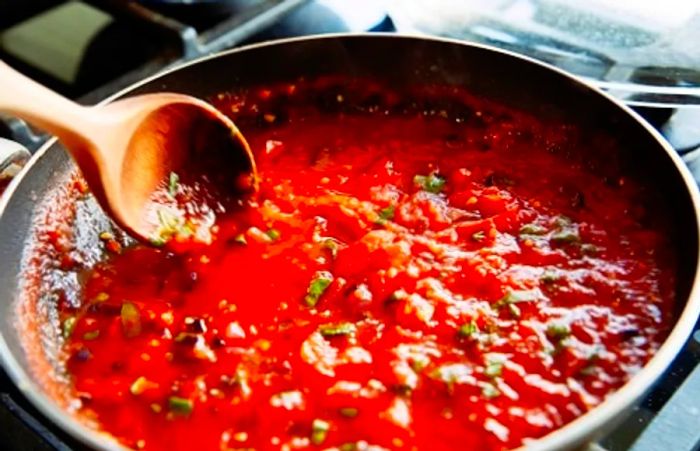 a pot of tomato sauce simmering on the stove