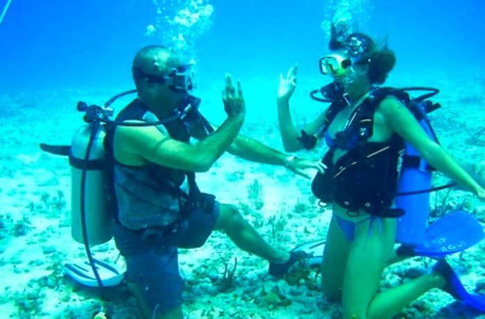 two divers giving a high five underwater