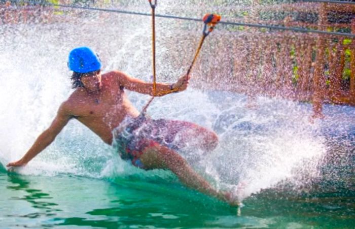 A man surfing on the waters at Maya Lost Mayan Kingdom adventure park without a board.