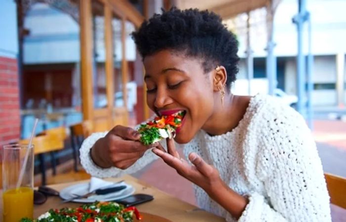 woman enjoying a slice of Italian pizza in downtown vancouver