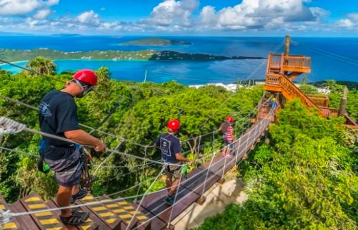 Tourists traversing a wooden bridge on their way to a zip line in St. Thomas