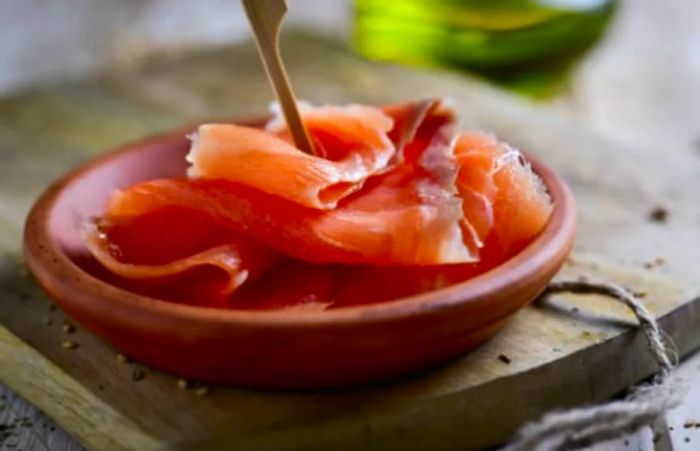 sliced smoked salmon presented in an orange bowl