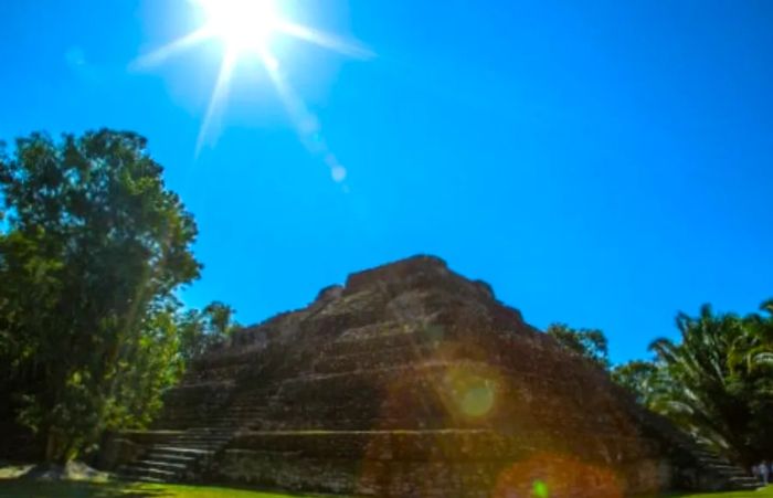 The sun illuminates a large pyramid at the Chacchoben Mayan ruins.