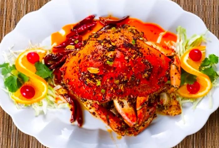 Dungeness crab prepared and served with bell peppers, orange slices, and cherries