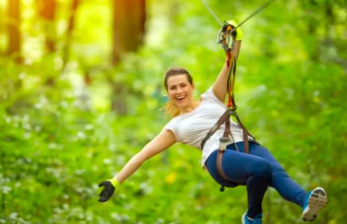 a woman zip lining through the scenic Sierra Madre foothills