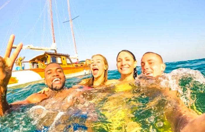 A group of friends capturing a selfie while swimming in the ocean off Cozumel's coast.