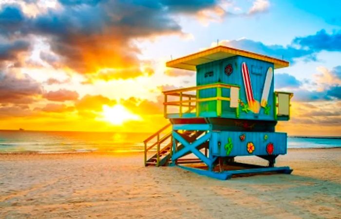 the sun setting over a lifeguard tower on Miami Beach