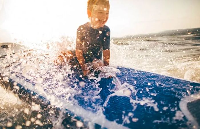 A young boy surfing the waves in San Juan.