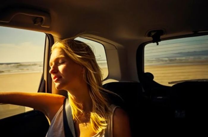 A woman gazing out the window during her private van journey.