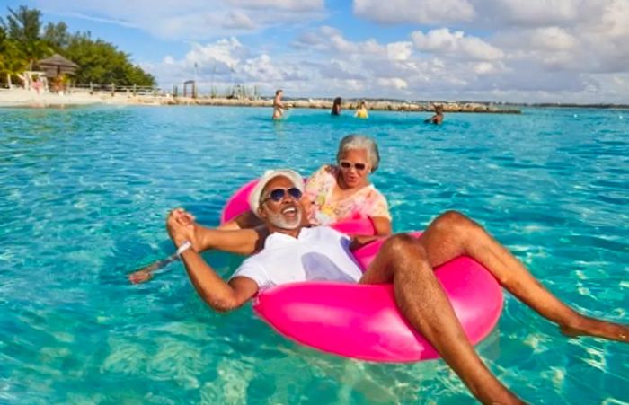 a senior couple enjoying a floaty at the beach