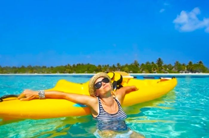 a woman relaxing on her yellow kayak while sunbathing in the waters of Freeport