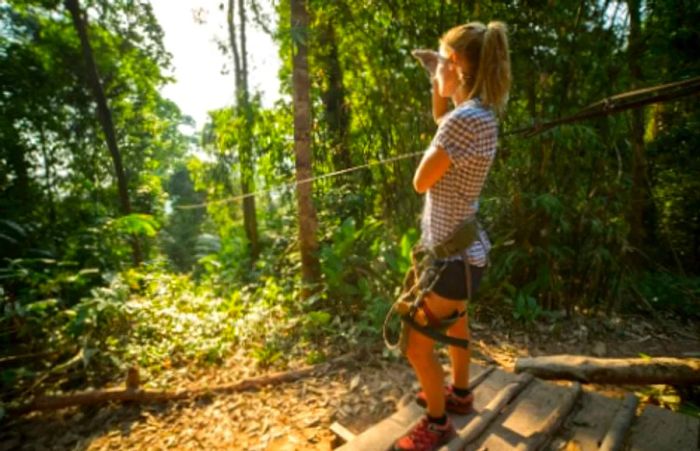 a woman admiring the forest view during her canopy adventure in Ketchikan